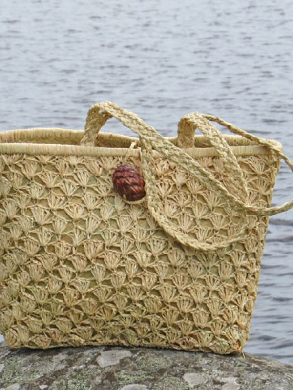 4. Bag with outside of crocheted raffia palm leaves, inside of plaited sedges. The shoulder straps of the bag are braided from raffia, the button is a seed pod from the raffia palm. Find the bag in the La Maison Afrique FAIR TRADE assortment by clicking below.