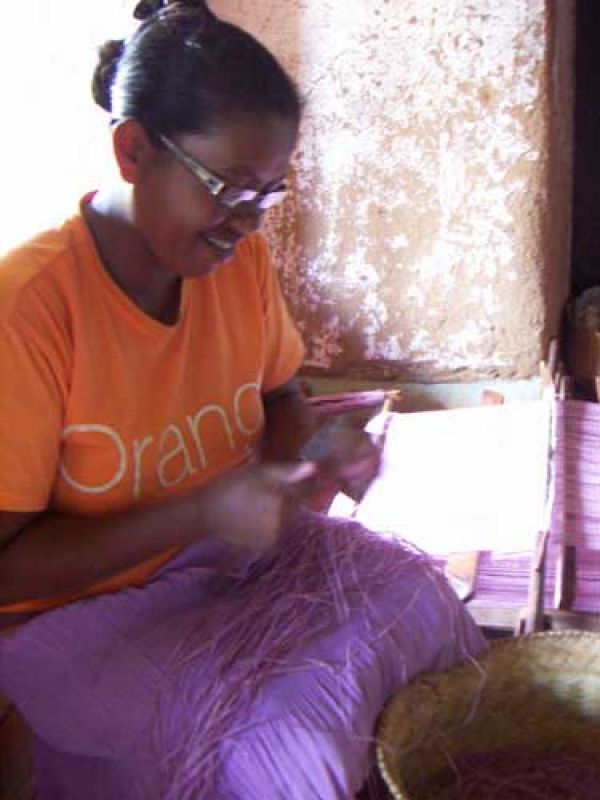 6. Before start weaving, Mme Laure splits the palmleaves lengthwise, ties in order to make a long thread, wind the thread on a quill.